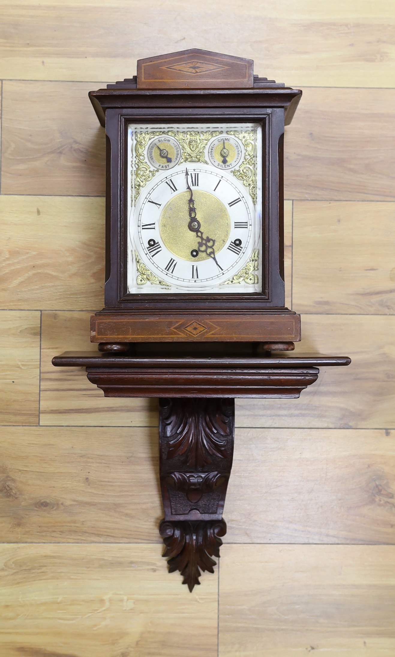 A Edwardian inlaid mahogany bracket clock, with traditional dial and chiming mechanism, clock 37cms high, bracket 33cms high